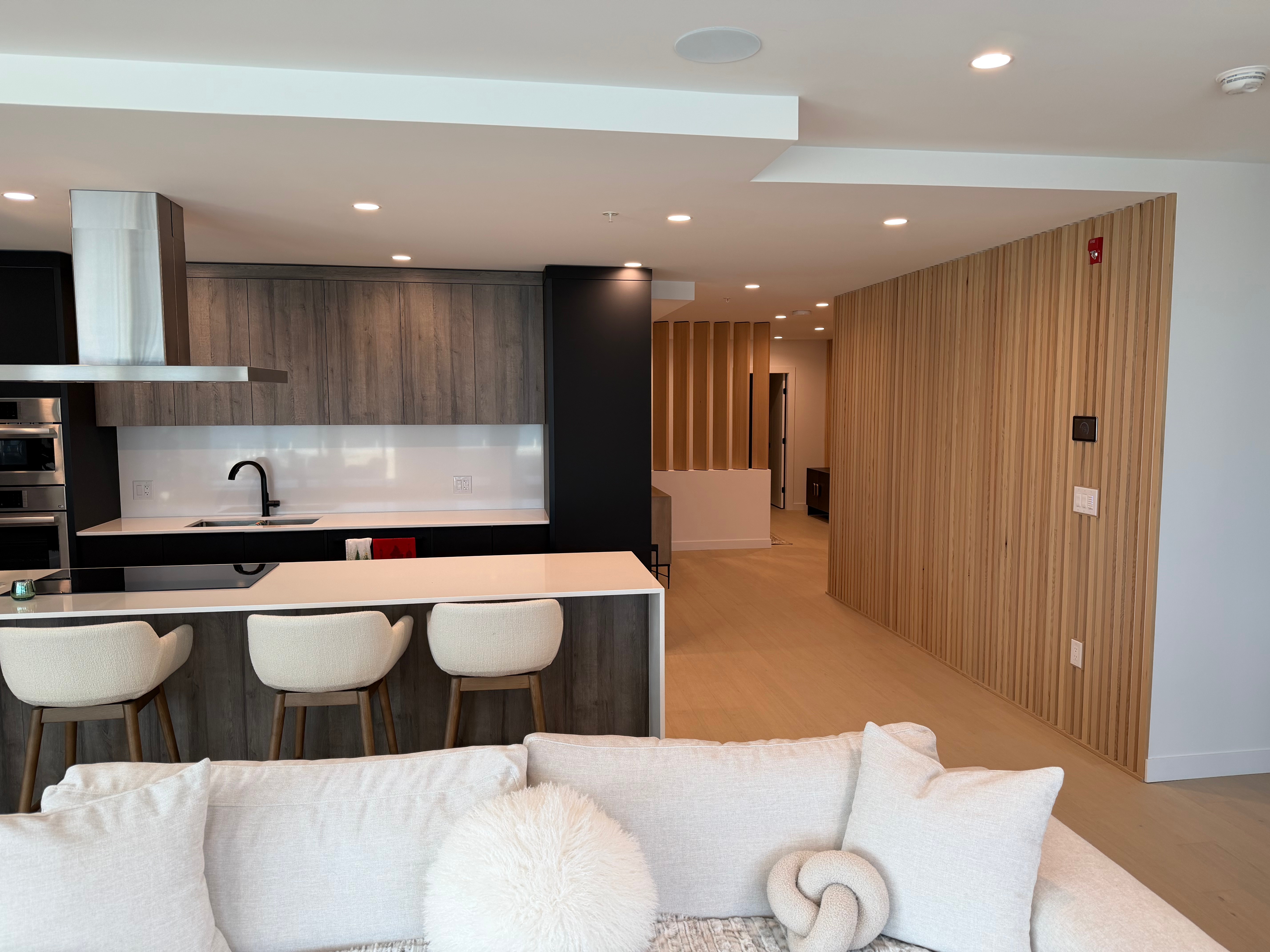 Vertical grain hemlock slat and louver walls, CNC fabricated and stained to complement white oak flooring.